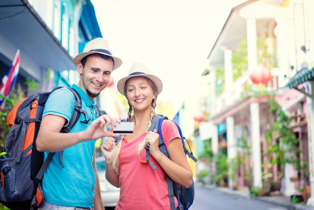 traveling couple with credit card in hands