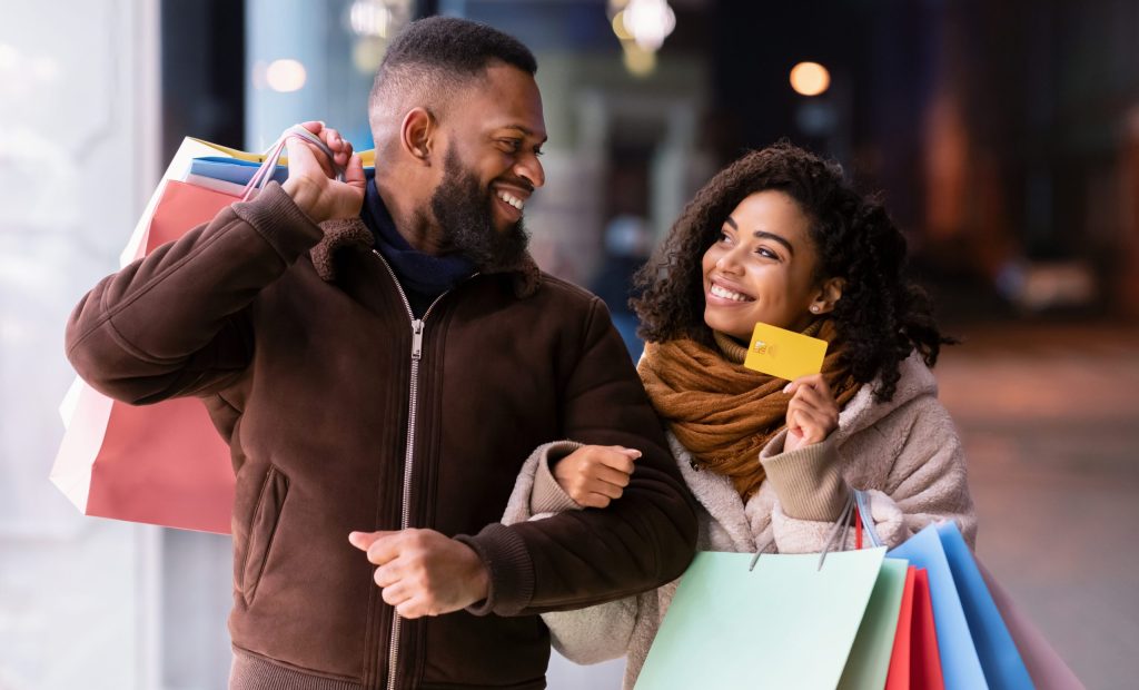 Portrait of happy afro couple holding credit card
